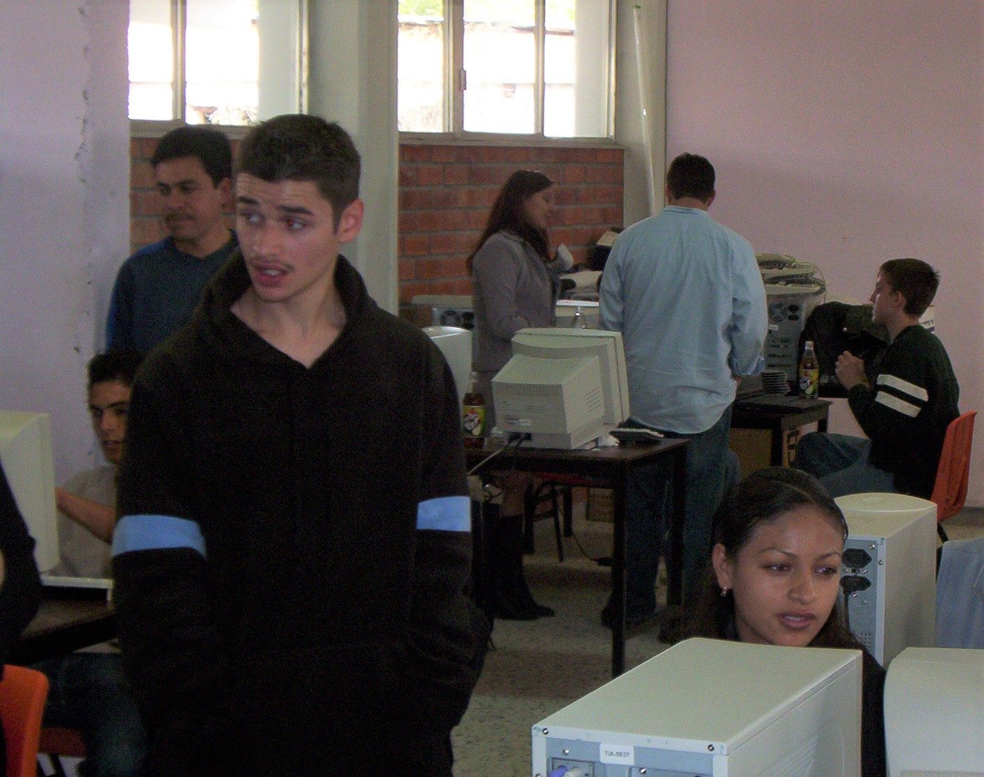 An older computer lab in Durango with CRT monitors, students and adults working together